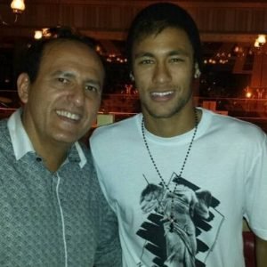 Edilásio Jr. ao lado de um jogador de futebol brasileiro, em um restaurante